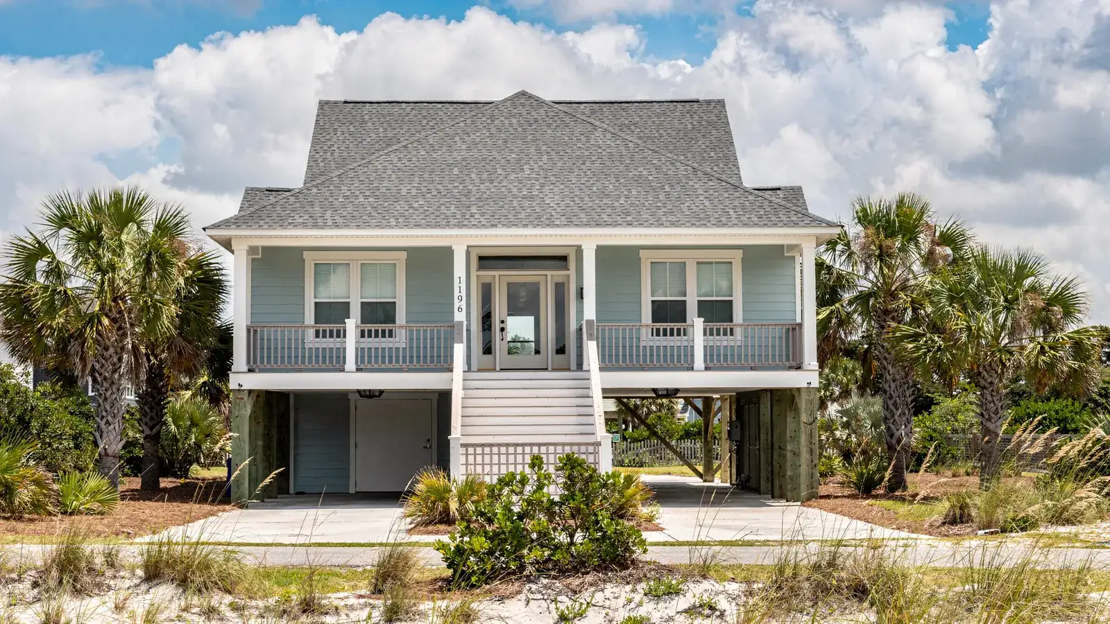 A raised coastal South Carolina home with a new architectural shingle roof and palmettos